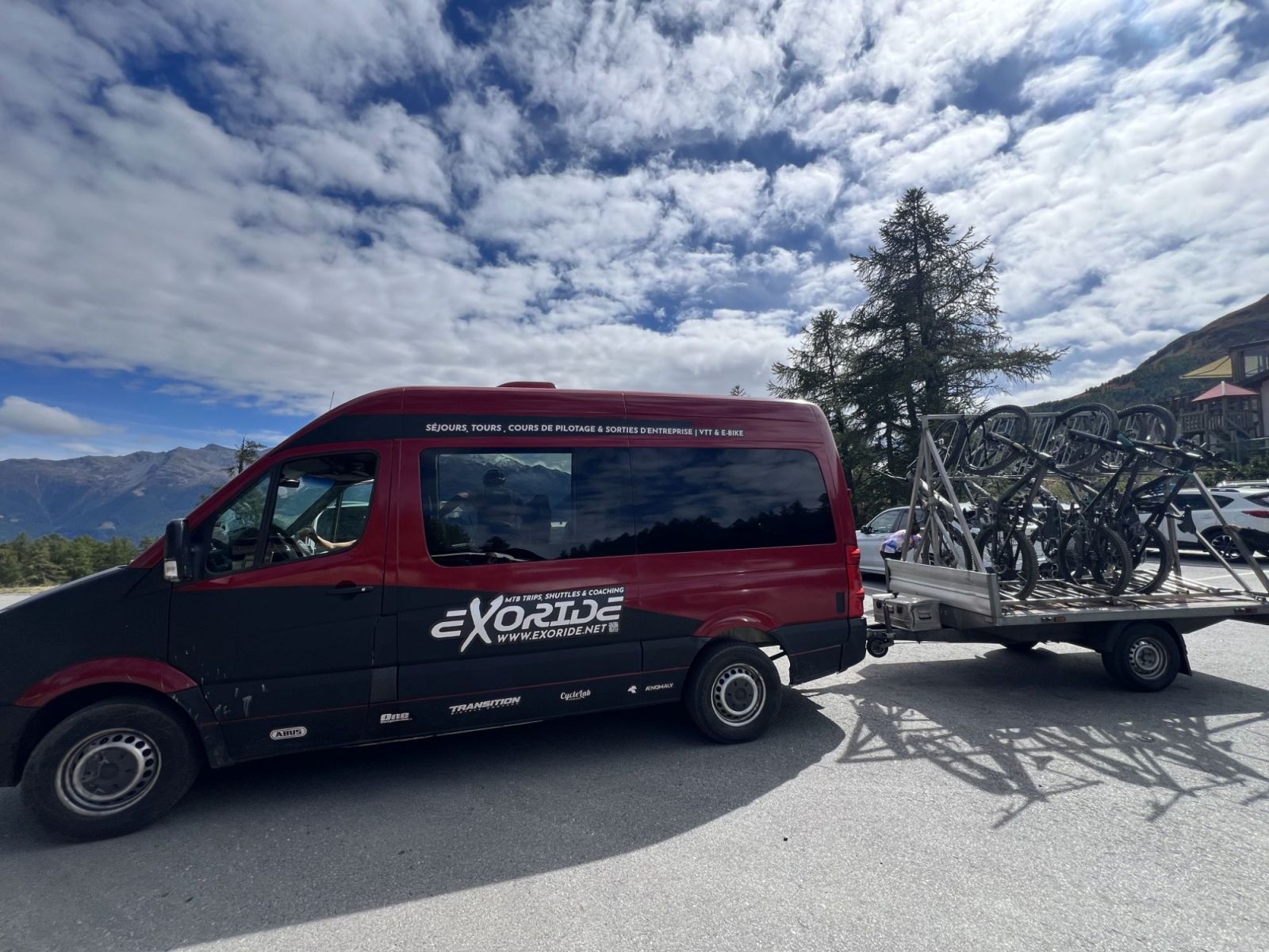 Exoride trailer seen from the side, each mountain bike on its own rack and strapped separately before the climb