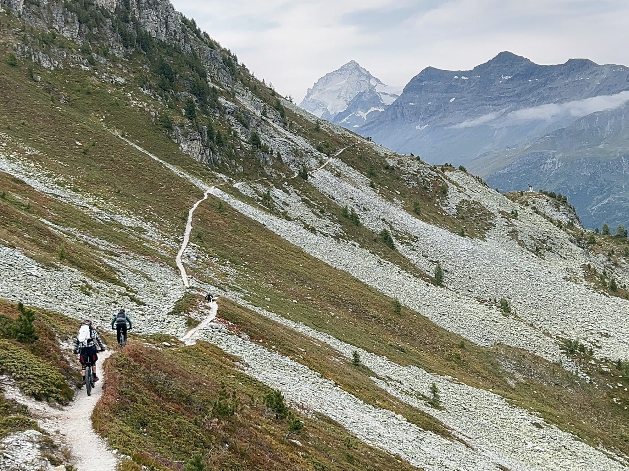Zwei Biker auf einem Panorama-Singletrail vor den Walliser Gipfeln, Bike-Saison 2027 mit Exoride
