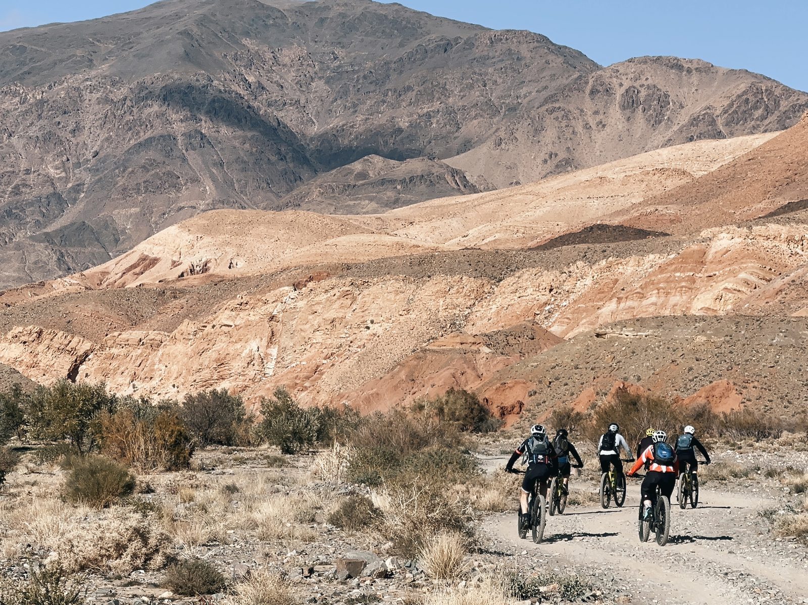 Eine kleine Gruppe auf dem Bike in den ockerfarbenen Bergen Südmarokkos, Reise Zagoride, Bike-Saison 2027 mit Exoride