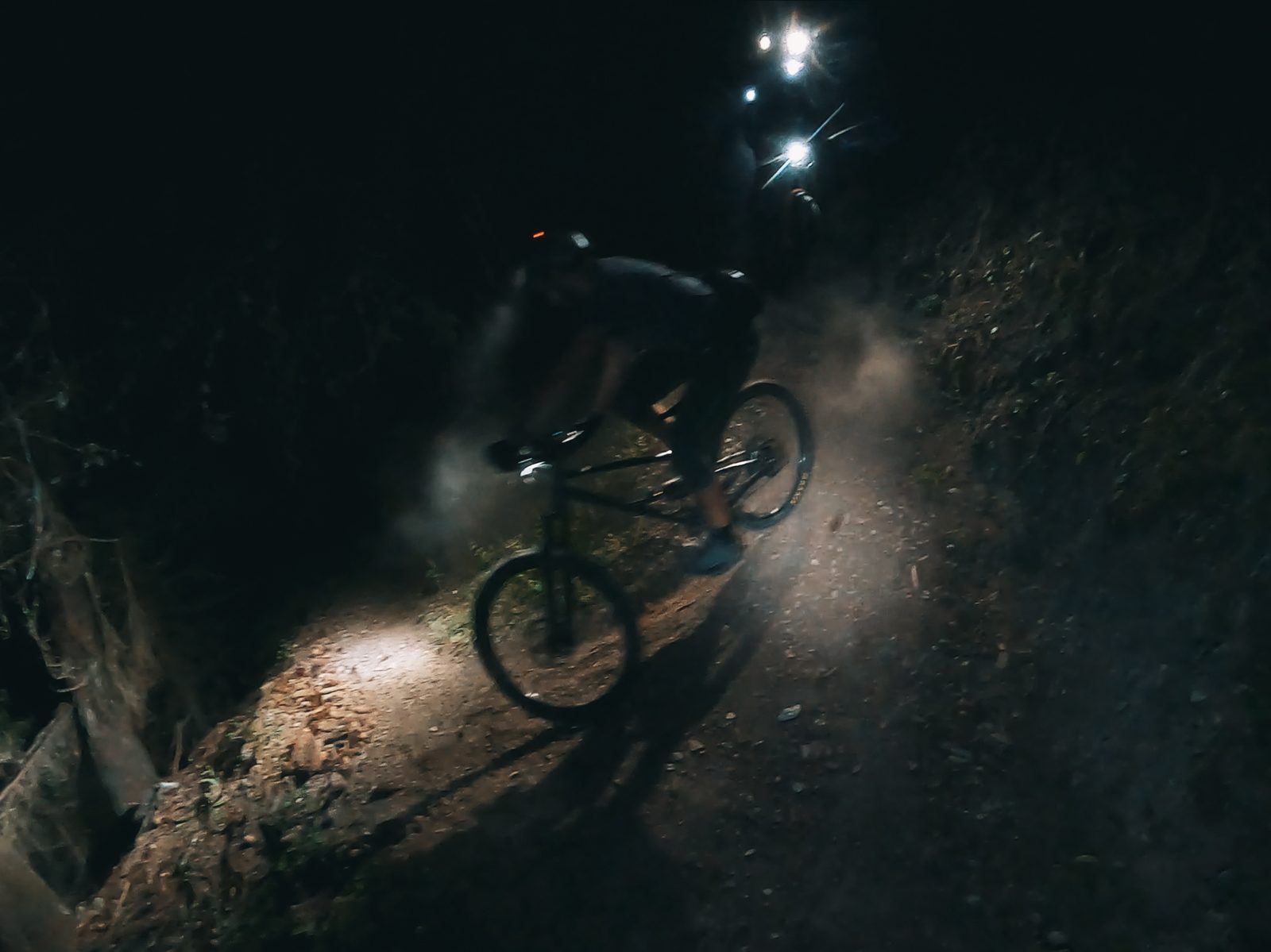 Biker in der Nacht mit Stirnlampen auf einem Walliser Trail, Fullmoon-Tag, Bike-Saison 2027 mit Exoride