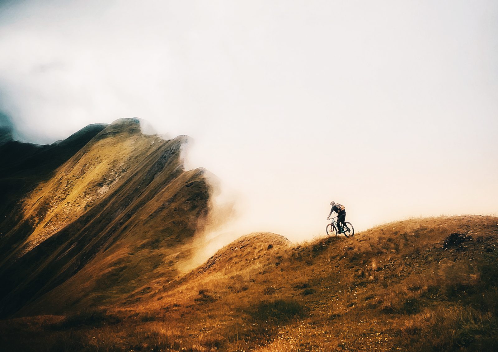 Ein Biker als Silhouette auf einem goldenen Kaukasus-Grat, Reise Kachapuride, Bike-Saison 2027 mit Exoride