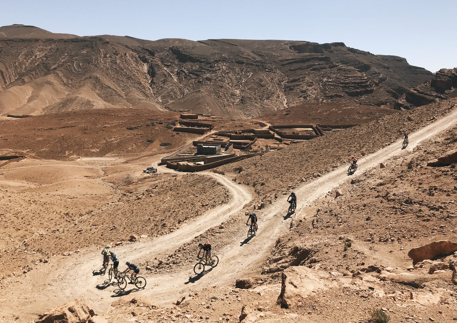 Des riders espacés sur une piste du sud marocain, chacun à son allure, séjour Zagoride, préparer son séjour VTT avec Exoride