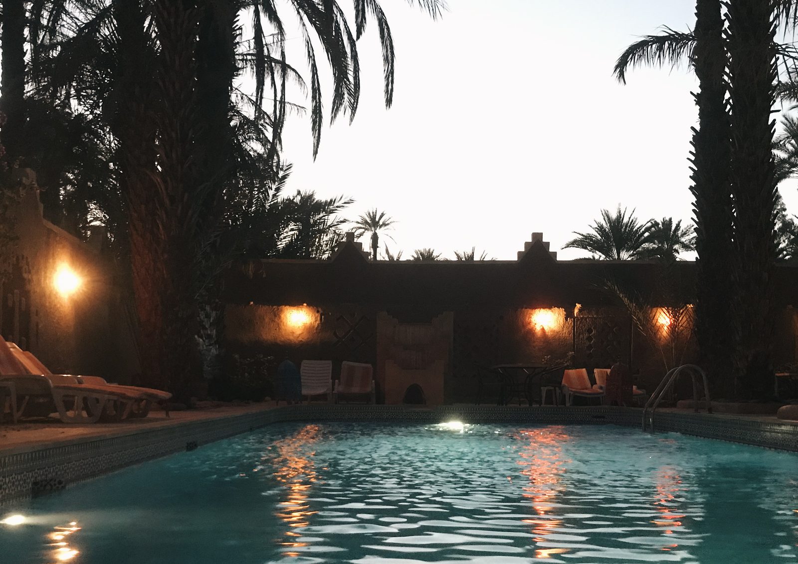 Der Pool einer Kasbah bei Einbruch der Nacht, unter Palmen, Reise Zagoride in Marokko mit Exoride